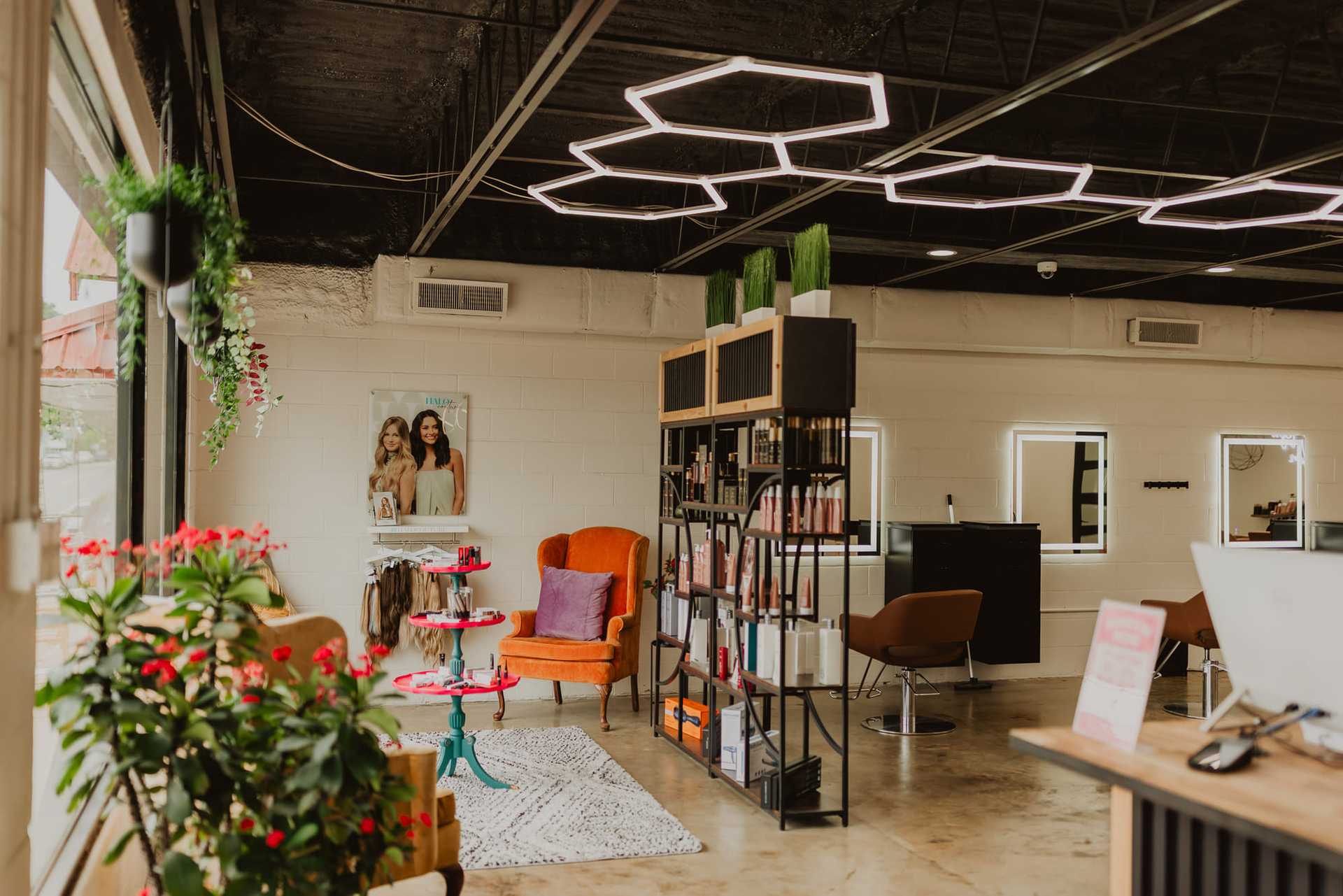 Chic salon interior with modern lighting, cozy seating, and a stylish decor.