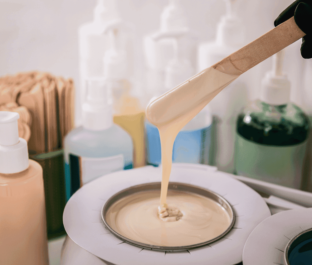 Wax being poured onto a heating device in a beauty salon.